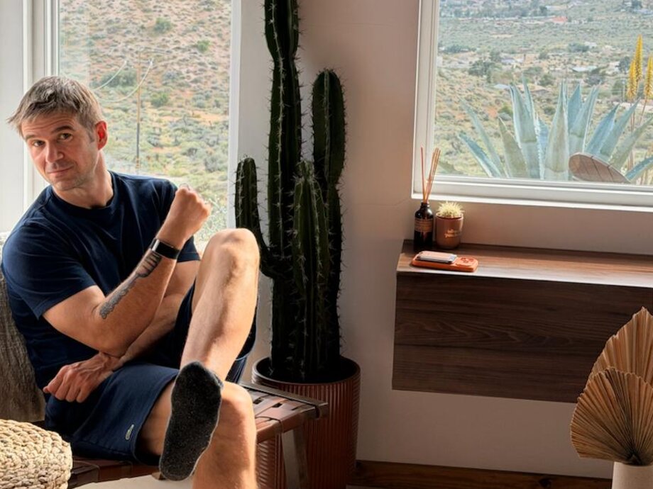 Clay Collins sitting by a window with a desert and mountain view